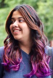A woman with purple hair and a blue shirt.
